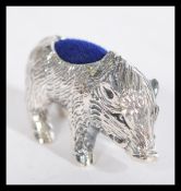 A sterling silver pin cushion in the form of a pig having a blue baize cushion. In the manner of