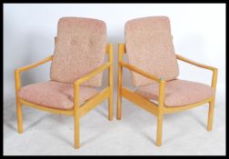 A pair of 20th century Ercol staff chairs. Light beech wood turned construction with shaped elbow