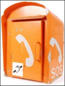 An original British 20th century industrial SOS motorway roadside empty tin phone box in a pastel