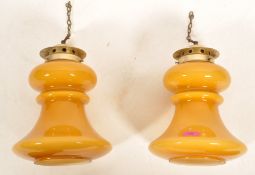 A pair of mid century large amber yellow glass hanging lantern pendant lamps. The cylindrical