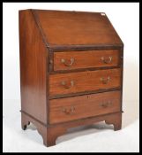 An Edwardian mahogany bureau being raised on brack
