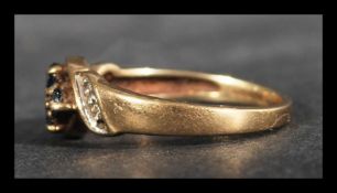 A hallmarked 9ct gold ring with central blue sapph