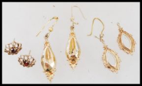 Three pair of 9ct gold earrings consisting of a flower head pierced example with central faceted