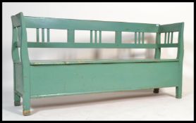 A large 20th century continental painted pine  hall settle bench having a hinged compartment to seat