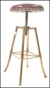 A 19th century tubular brass and tan brown buttoned leather revolving piano stool set over downswept