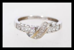 A hallmarked 9ct white gold ring set with princess cut CZ in a crossover setting. Hallmarked