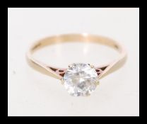 A vintage hallmarked 9ct yellow gold ring set with a solitaire white stone in a prong setting.