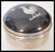 A silver hallmarked and tortoiseshell lidded trinket pot having an inlaid cockerel to lid.
