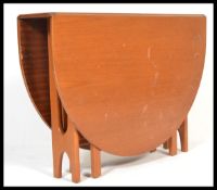 A 1970's teak wood Danish influenced G-Plan drop leaf dining table raised on shaped supports with