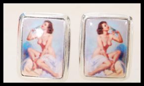 A set of sterling silver cuff links with enamel panels depicting a nude model.