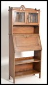 A 19th century Arts & Crafts oak students bureau bookcase. Twin glass bookcase over central bureau