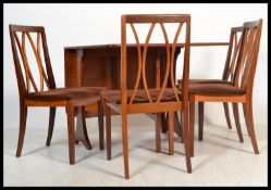 A retro 20th Century G-Plan teak wood drop leaf dining table together with a set of four teak G-Plan