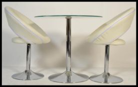 A contemporary chrome and glass tulip table together with a pair of chrome and white leather