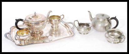 A civic pewter tea service including a bulbous form hammered tea pot and tea cups having a silver