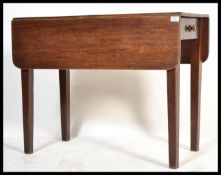 A 19th century Georgian mahogany pembroke dining / occasional table being raised on square tapered