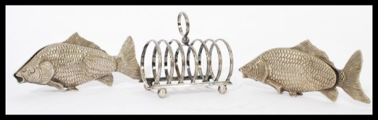 A pair of silver plated novelty menu holders in the form of fish along with a six section silver