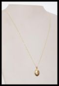 A hallmarked 9ct gold locket pendant necklace set on a fine 9ct gold necklace chain.