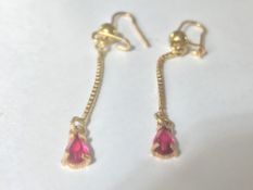 A pair of 18ct gold drop earrings having box link droplets with faceted red stones. Marked 750 tests