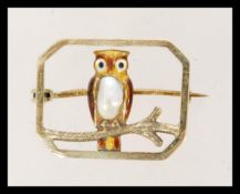 A 10ct gold brooch having an enamel owl with natural pearl to the body. Measures 2.3 cms wide and