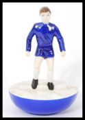 A Royal Doulton Subbuteo ceramic football figurine MCL 12 featuring a player in blue kit on blue and