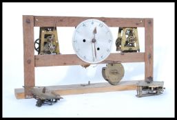 A vintage early 20th century factory slave clock having an open skeleton type movement on wooden