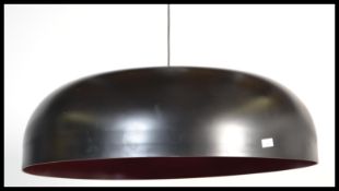 A contemporary large UFO type pendant lamp - ceiling ligh shade having a black outer with red