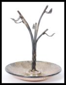 A silver hallmarked ring stand having a slopped bowl with naturalistic leaf branch to centre.