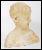 A vintage early 20th century plaster work bust of a smiling boy with impressed marks to verso