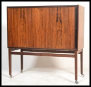 A 1970's Danish inspired teak wood tambour fronted entertainment cabinet. The tambour door opening