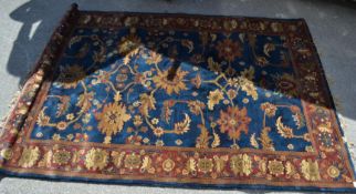 A floor carpet red and blue ground rug with a central panel having a tree of life design and a