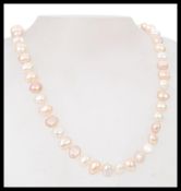A 20th century necklace of cream and white fresh waster pearls. The length is 18 inches and it