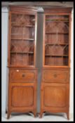 A pair of tall 19th century Regency mahogany pedestal library bookcase cabinets being raised on