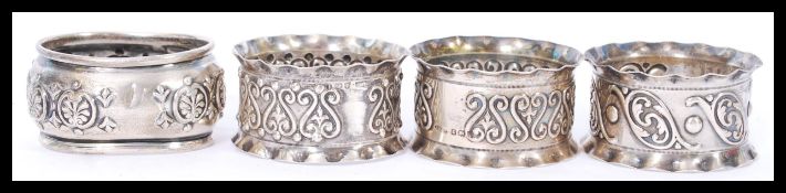 A collection of 4 silver hallmarked napkin rings to include a pair and 1 by E Silver & Co,