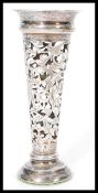 An early 20th century silver hallmarked trumpet vase having pierced decoration of scrolls and