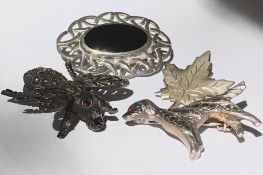 A collection of four vintage brooches to include a silver and marcasite figural brooch in the form