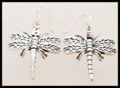 A contemporary pair of silver dragon fly earrings with articulated wings. They are 3.5cm in length.