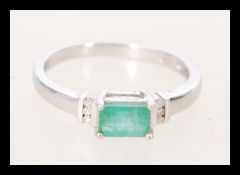 A hallmarked 9ct white gold emerald and diamond ring.  Hallmarked Sheffield. Weight 2g. Size O.