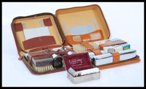 Two vintage 20th Century leather cased vanity sets together with a Gillette Safety razor housed