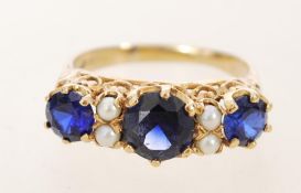 A mid 20th century 9ct gold ring with three sapphires in decorative prong settings with pearl