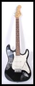 A vintage electric six string guitar by Evolution having a black body with white scratch guard and
