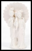 An early 20th century Blanc De Chine ceramic figurine group depicting two Geisha's under a