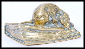 A 19th century Victorian heavy brass desk paperweight in the form of a mouse seated on an antique