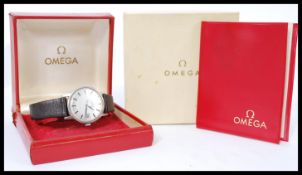 A vintage Omega Geneve wrist watch having a silvered dial with baton numerals and faceted hands.