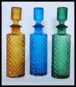 A collection of three vintage / retro 20th Century studio art glass decanters / bottle, each in a