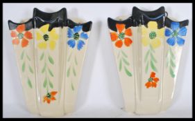 A pair of earl 20th Century Art Deco ceramic hand painted wall pockets, hand painted floral