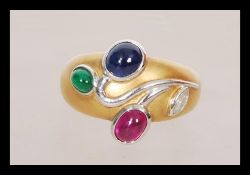 An 18ct yellow gold ruby, emerald, Sapphire and diamond ring in the Art Nouveau manner having