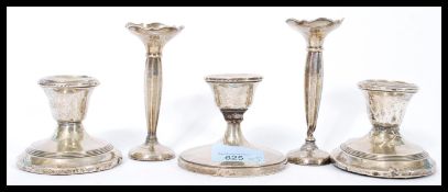 A group of five silver hallmarked filled candlesticks to include a pair of stub candlesticks, a pair