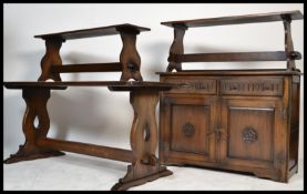 A 20th century Jacobean revival oak refectory dining table together with 2 benches and a matching
