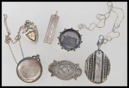 A group of silver hallmarked items to include a ingot, pocket watch case, fob, locket pendant, and
