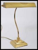 A vintage 20th century brass bankers lamp raised on a circular base with adjustable shade.